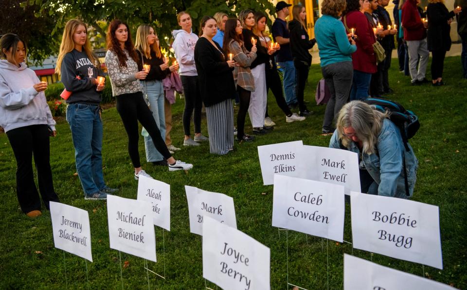 Heather Cox places the sign remembering Mark Ewell on the Monroe County Courthouse lawn during the Homeless Memorial Vigil on Thursday, Sept. 29, 2022.