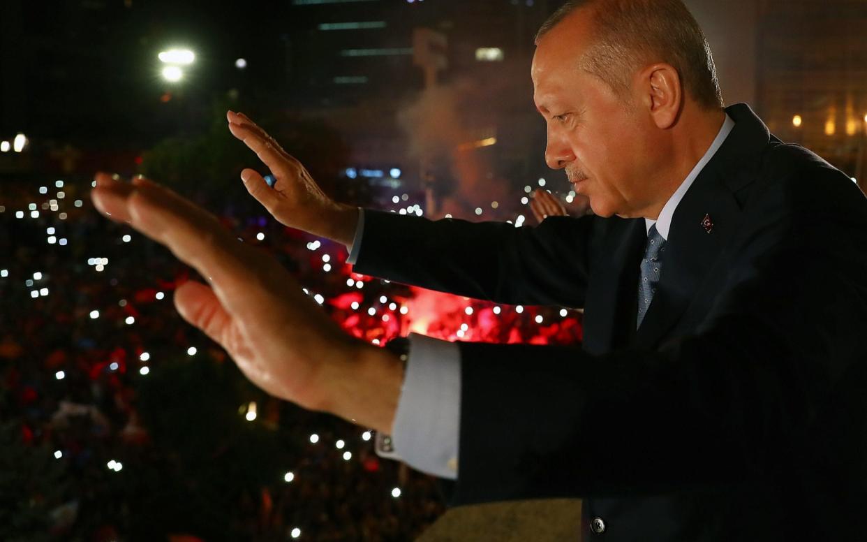 President of Turkey and leader of the Justice and Development Party Recep Tayyip Erdogan greets the crowd at a late night victory speech - Anadolu