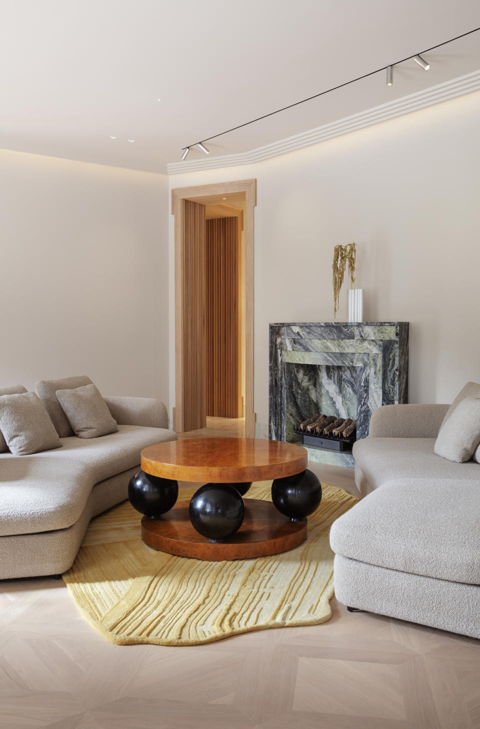 A small living room with a textured rug in an organic shape