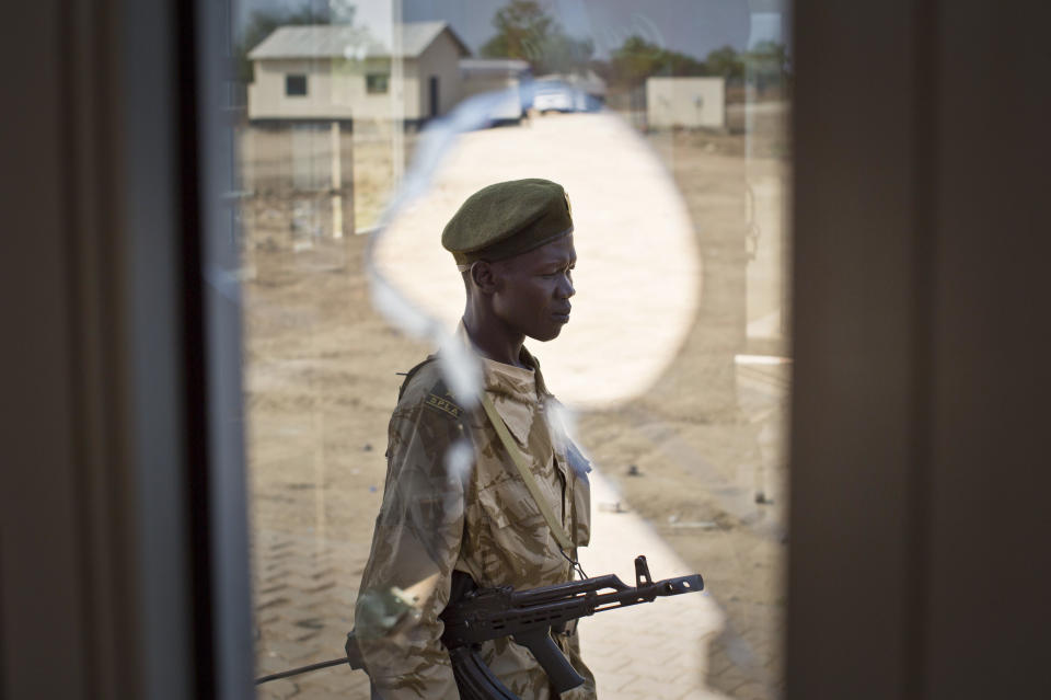 A South-Sudanese government soldier is seen through a broken window at the airport in Bor, Jonglei State, South Sudan Sunday, Jan. 19, 2014. Leaders for warring sides in South Sudan's monthlong internal conflict say they are close to signing a cease-fire and the South Sudanese military spokesman said that army forces had retaken the key city of Bor Saturday, defeating 15,000 rebels. (AP Photo/Mackenzie Knowles-Coursin)