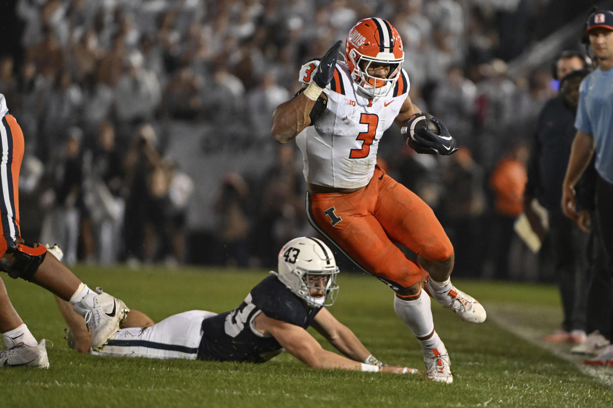 llinois running back Kaden Feagin (3) gains yardage past Penn State linebacker Tyler Elsdon, bottom, during the first quarter of an NCAA college football game, Saturday, Sept. 28, 2024, in State College, Pa. (AP Photo/Barry Reeger)