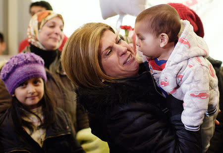 Tima Kurdi (middle), holds her nephew Sherwan Kurdi as she welcomes her brother Mohammed Kurdi (not shown), and his family at Vancouver International airport in Vancouver, British Columbia, December 28, 2015. REUTERS/Jimmy Jeong