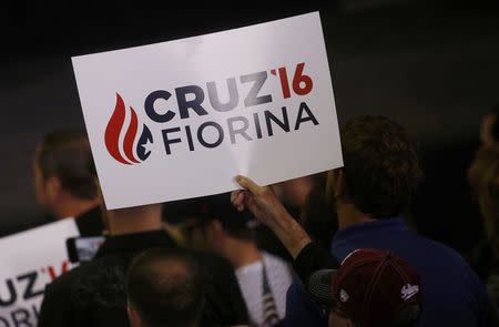 A supporter of Republican U.S. presidential candidate Ted Cruz holds up a new campaign sign reflecting Cruz's choice of Carly Fiorina as his running mate at a campaign rally in Indianapolis, Indiana, United States April 27, 2016. REUTERS/Aaron P. Bernstein