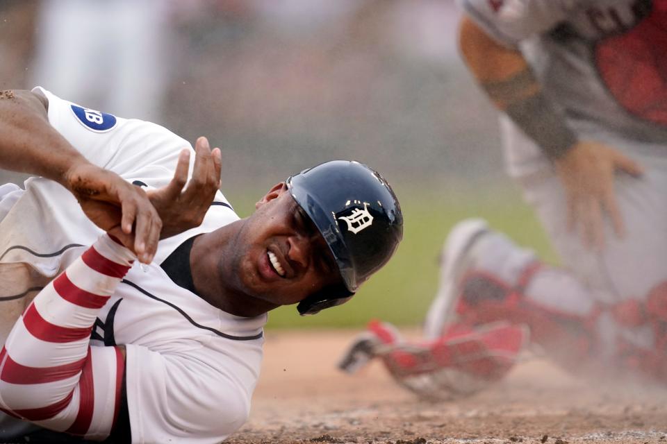 Tigers second baseman Jonathan Schoop rolls after beating the tag of Guardians catcher Sandy Leon during the third inning of Game 2 of the doubleheader against the Guardians on  Monday, July 4, 2022, at Comerica Park.