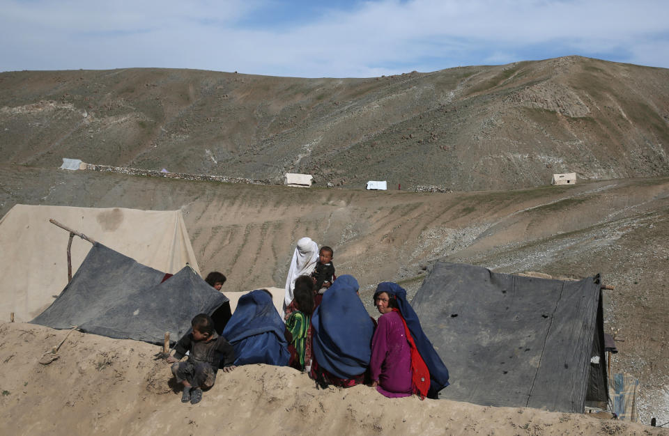 Survivors sit in front of their tents near the site of Friday's landslide that buried Abi-Barik village in Badakhshan province, northeastern Afghanistan, Tuesday, May 6, 2014. Authorities tried to help families displaced by the torrent of mud that swept through Abi-Barik village after hundreds were killed. (AP Photo/Massoud Hossaini)