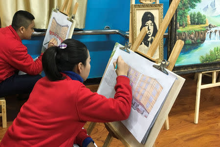 Residents at the Karakax county vocational educational training centre draw the centre during an arts class while reporters are present during a government organised visit in Karakax country, Xinjiang Uighur Autonomous Region, China, January 5, 2019. REUTERS/Ben Blanchard