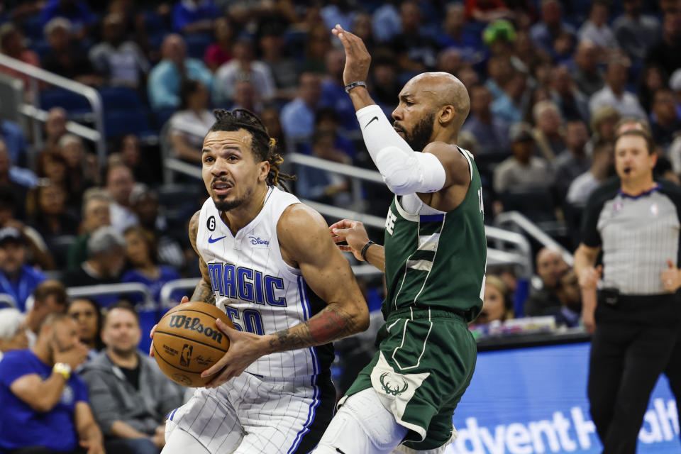 Orlando Magic guard Cole Anthony (50) drives around Milwaukee Bucks guard Jevon Carter during the first half of an NBA basketball game Tuesday, March 7, 2023, in Orlando, Fla. (AP Photo/Kevin Kolczynski)