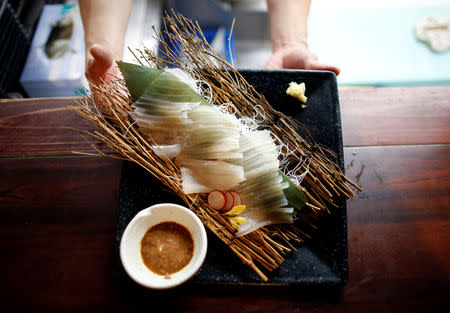 A chef serves flying squid sashimi at a seafood restaurant in Tokyo, Japan, September 27, 2018. REUTERS/Issei Kato/Files