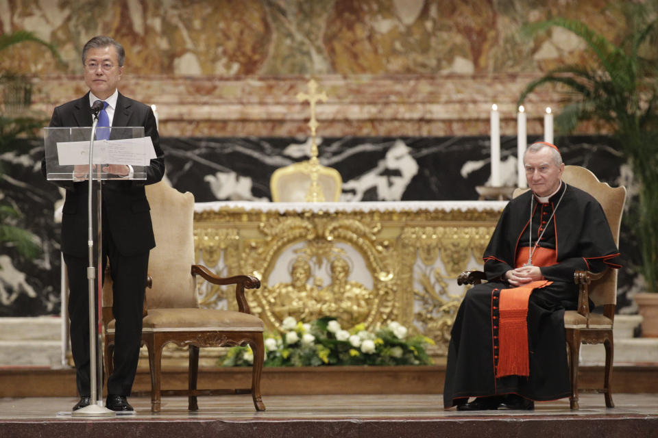 Vatican Secretary of State Pietro Parolin, right, listens to South Korean President Moon Jae-in delivering a speech at the end of a Mass for peace inside St. Peter's Basilica at the Vatican, Wednesday, Oct. 17, 2018. South Korea's president is in Italy for a series of meetings that will culminate with an audience with Pope Francis at which he's expected to extend an invitation from North Korean leader Kim Jong Un to visit. (AP Photo/Gregorio Borgia)