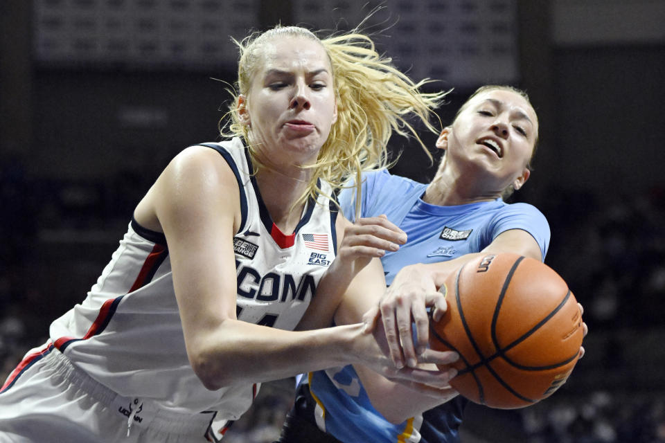 Connecticut's Dorka Juhasz, left, and Marquette's Emily La Chapell reach for a rebound in the second half of an NCAA college basketball game, Saturday, Dec. 31, 2022, in Storrs, Conn. (AP Photo/Jessica Hill)