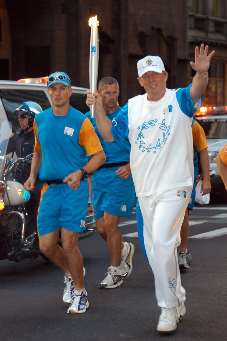 Jogging with the Olympic torch for the 2004 Games in Athens, Greece. (Photo: Getty Images)