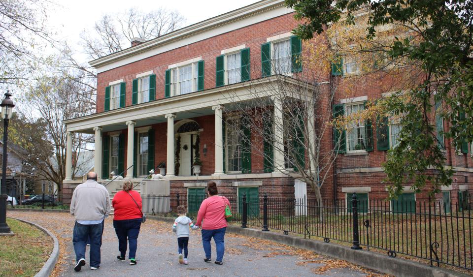 A family walks in front of the Centre Hill Mansion Museum on their way to the PPTF Christmas open house in Petersburg on Dec. 5, 2020.