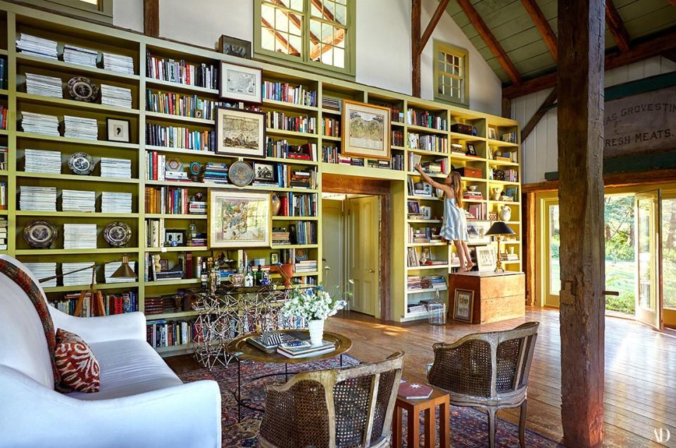 Benjamin Moore’s Georgian Green paint covers the great room’s bookshelves. Casamidy console; vintage cocktail table; Louis XV barrel-back caned chairs.