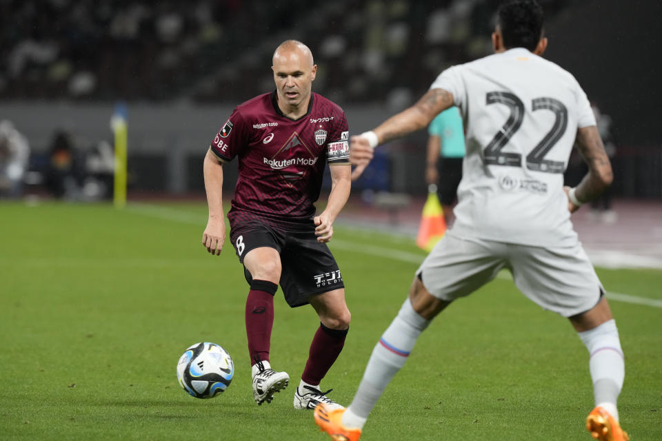 Vissel Kobe's Andres Iniesta, battle for control of the ball with Barcelona's Raphinha during a friendly soccer match between his Japanese club Vissel Kobe and his old club Barcelona at the National Stadium in Tokyo, Tuesday, June 6, 2023. (AP Photo/Eugene Hoshiko)