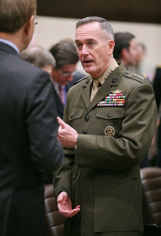 International Security Assistance Force and United States Forces-Afghanistan (ISAF) Commander General Joseph Dunford talks with other delegates before a bilateral meeting at NATO headquarters on February 22, 2013 in Brussels. NATO may station up to 12,000 troops in Afghanistan to train and assist Kabul's forces after its combat mission against the Taliban ends there in 2014, US officials said