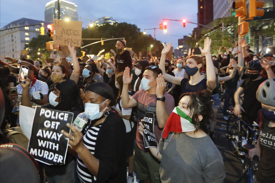 In this June 3, 2020 file photo, protesters confront New York Police officers as part of a solidarity rally calling for justice over the death of George Floyd in the Brooklyn borough of New York. Concerned about people packed in tightly during the recent protests, New York Gov. Andrew Cuomo says the thousands of people protesting the death of George Floyd have a "civic duty" to be tested for the coronavirus. (AP Photo/Frank Franklin II)