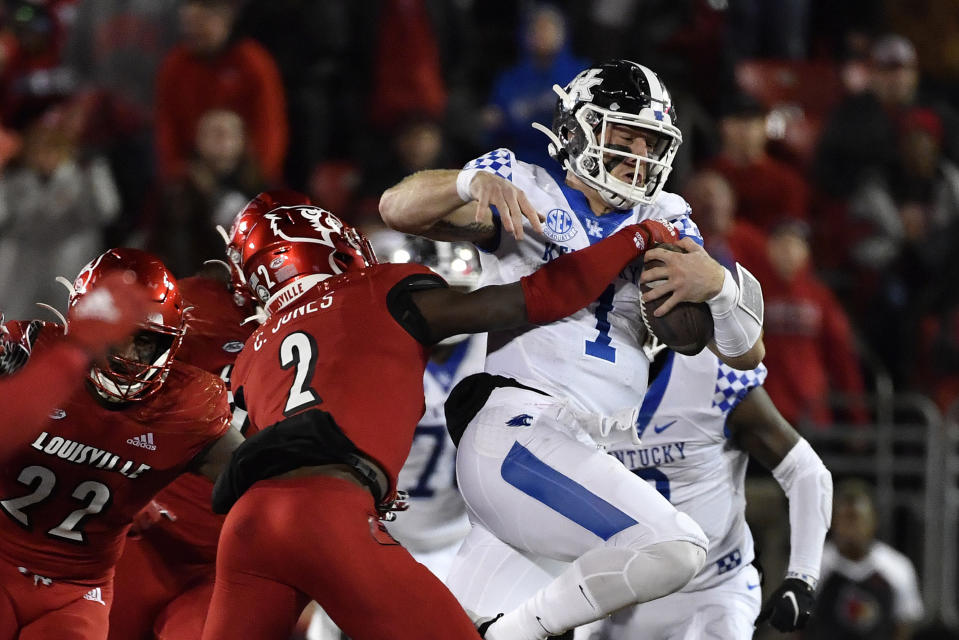 Kentucky quarterback Will Levis (7) is grabbed by Louisville defensive back Chandler Jones (2) during the first half of an NCAA college football game in Louisville, Ky., Saturday, Nov. 27, 2021. (AP Photo/Timothy D. Easley)