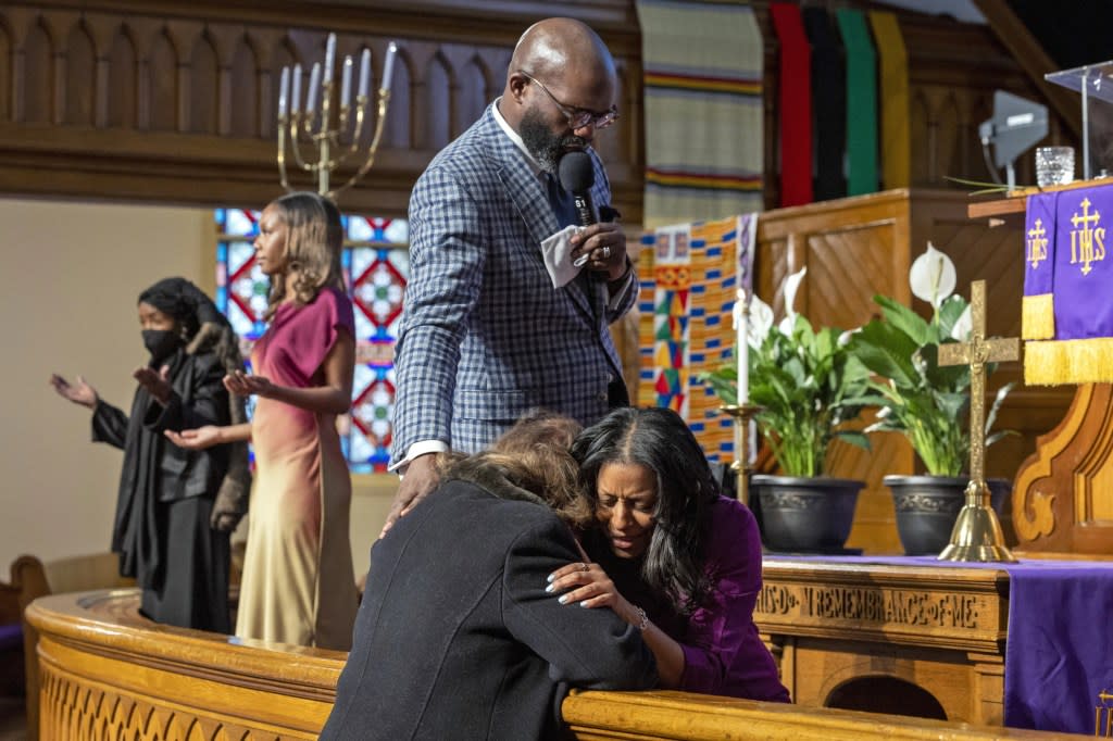 Rev. William H. Lamar IV, top, and Rev. Cozette Thomas, right, pray with a parishioner during Palm Sunday services at the Metropolitan AME Church in Washington, Sunday, March 24, 2024. (AP Photo/Amanda Andrade-Rhoades)