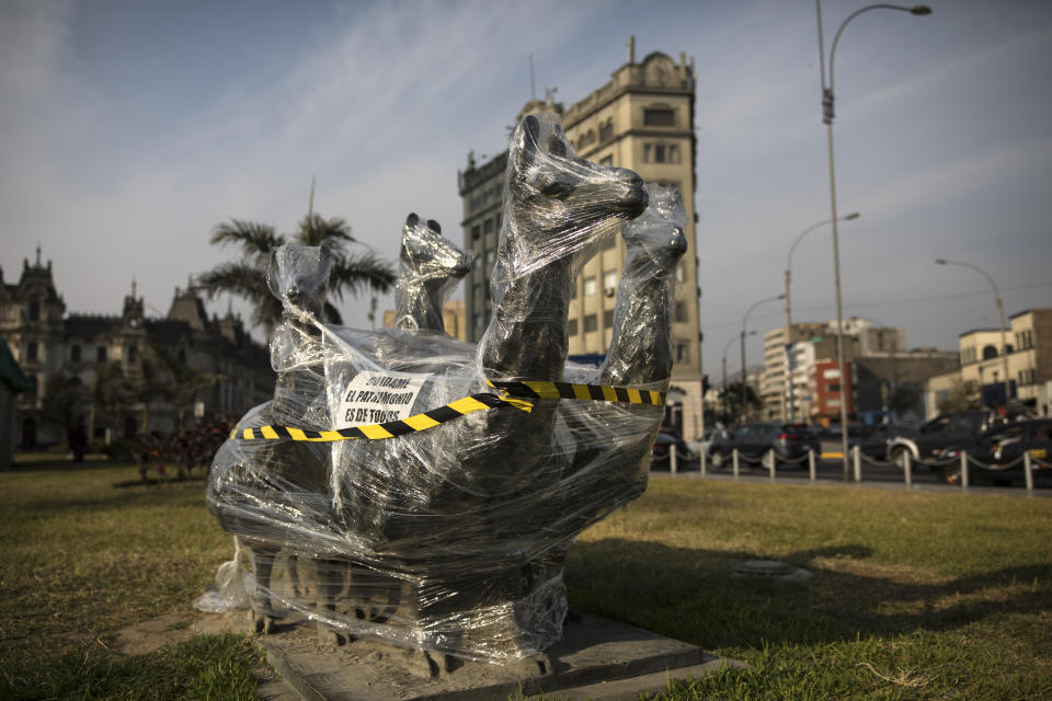 A bronze sculpture of four llamas is wrapped in plastic near the Palace of Justice in Lima, Peru, Saturday, Nov. 21, 2020. The municipality of Lima for the the first time in 485 years took precautions to protect historical monuments and statues, while Peru was mired in a whirlwind of demonstrations and a political crisis that resulted with three presidents in nine days. (AP Photo/Rodrigo Abd)