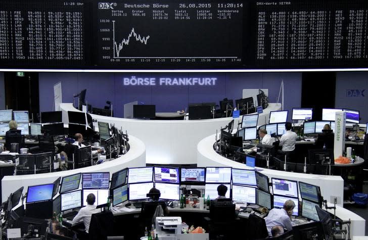 Traders are pictured at their desks in front of the DAX board at the stock exchange in Frankfurt, Germany, August 26, 2015. REUTERS/Staff/remote