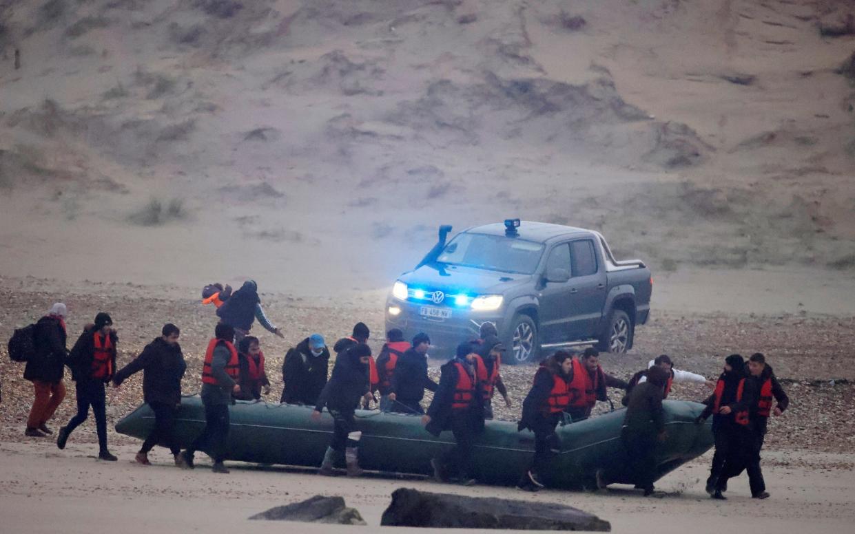 French police watch the group on the beach - REUTERS