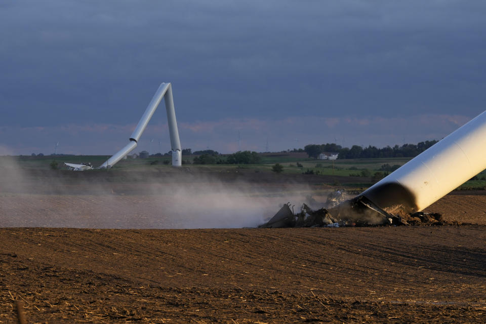 The remains of two tornado-damaged wind turbine touch the ground in a field, Tuesday, May 21, 2024, near Prescott, Iowa. (AP Photo/Charlie Neibergall)