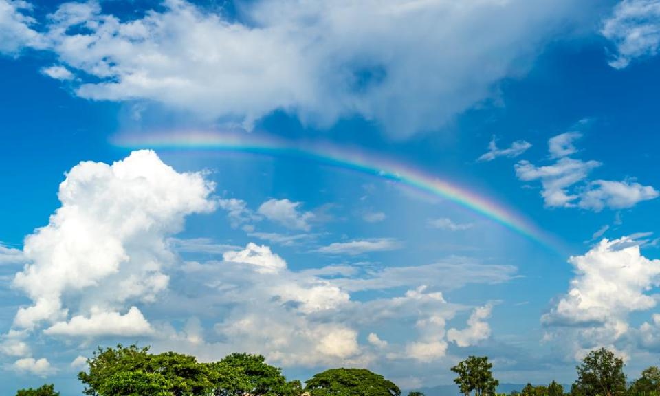 rainbow in blue sky in grassland