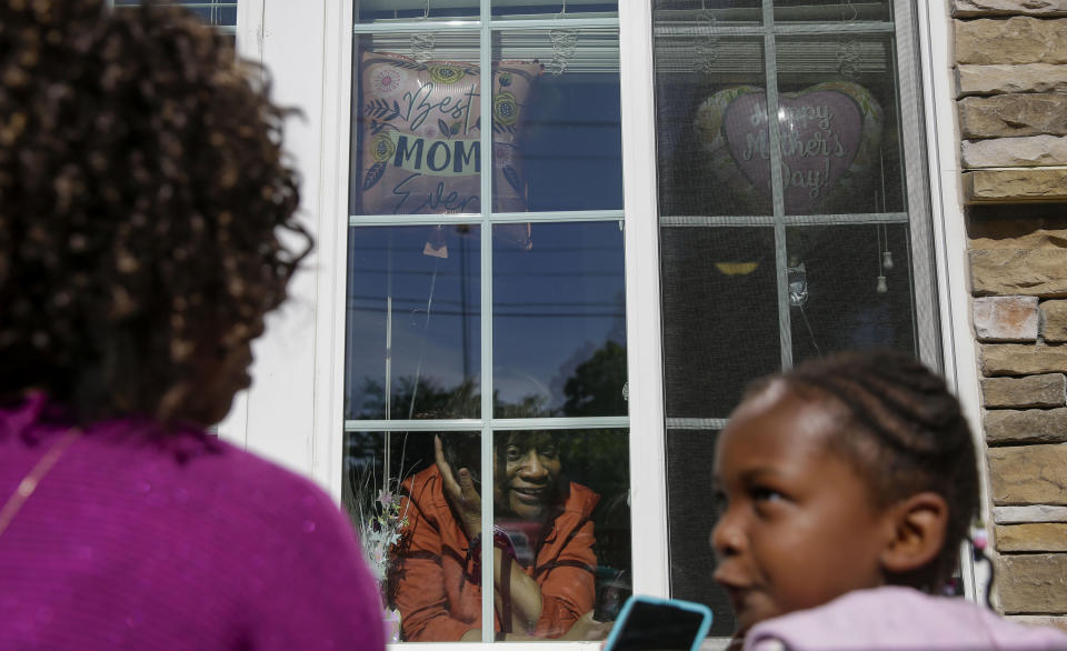 Mary Washington, 73, speaks through a window to her daughter, Courtney Crosby and grandchild Sydney Crosby for a Mother's Day celebration at Provident Village at Creekside senior living on Sunday, May 10, 2020, in Smyrna, Ga. (AP Photo/Brynn Anderson)