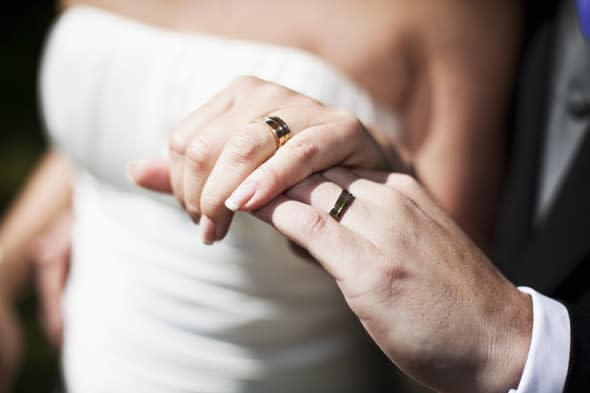 Hands of bride and groom showing their wedding rings