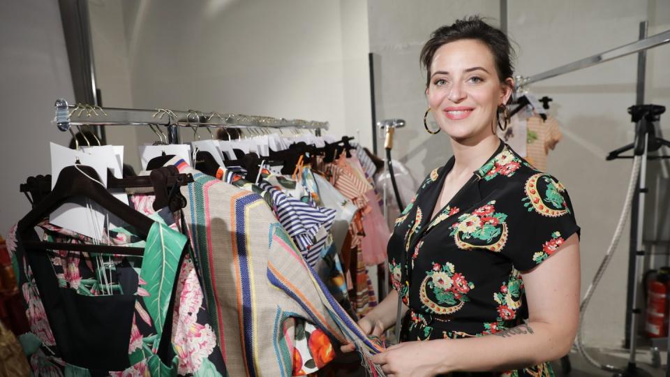 Designerin Lena Hoschek neben ihren Kleidern auf der Fashion Week 2018. Foto: Jörg Carstensen