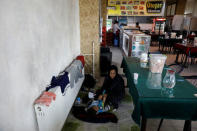 An Afghan migrant mother changes her child's nappies at a restaurant of a bus terminal, as they struggle to find buses to take them to western Turkish cities, after crossing the Turkey-Iran border in Agri, eastern Turkey, April 11, 2018. Picture taken April 11, 2018. REUTERS/Umit Bektas