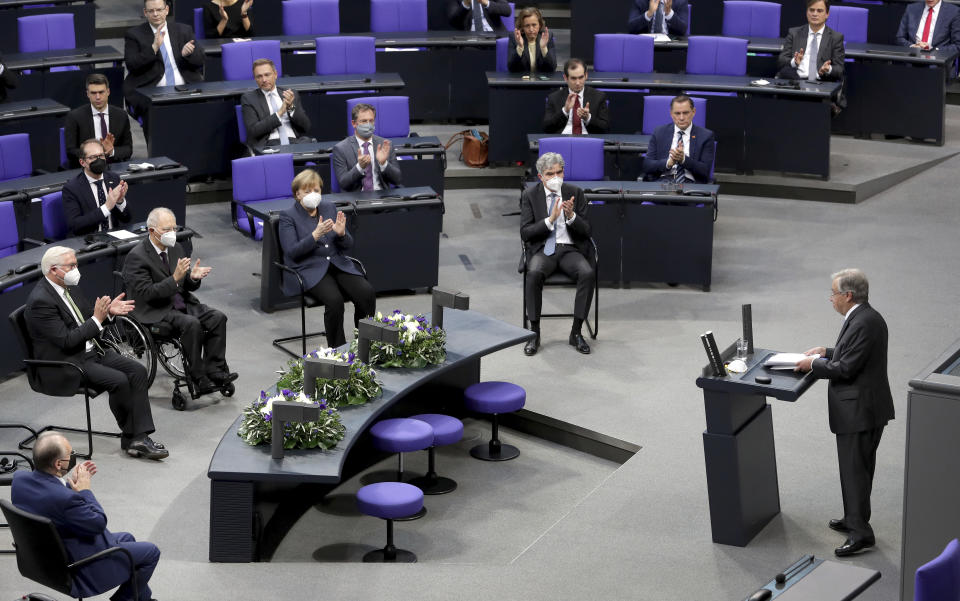 German Chancellor Angela Merkel, front center, and lawmaker applause after UN Secretary-General Antonio Guterres, front right, delivered a speech during a meeting of the German federal parliament, Bundestag, at the Reichstag building in Berlin, Germany, Friday, Dec. 18, 2020. (AP Photo/Michael Sohn)