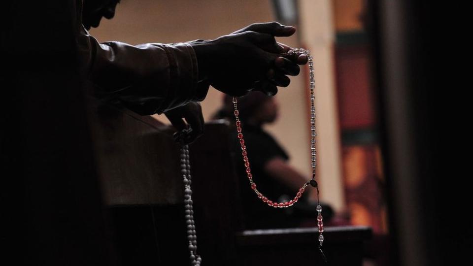 Una persona con un rosario cristiano