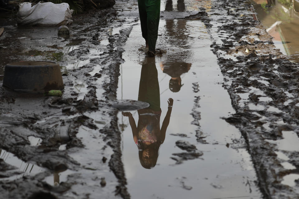 A young resident walks past a mud-covered road after floodwaters caused by Typhoon Goni rose inside their village in Batangas city, Batangas province, south of Manila, Philippines on Monday, Nov. 2, 2020. Super typhoon Goni left wide destruction as it slammed into the eastern Philippines with ferocious winds early Sunday and about a million people have been evacuated in its projected path. (AP Photo/Aaron Favila)