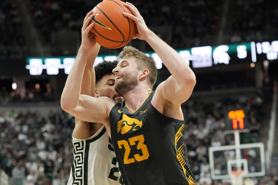 Iowa forward Ben Krikke (23) is defended by Michigan State forward Malik Hall during the first half of an NCAA college basketball game, Tuesday, Feb. 20, 2024, in East Lansing, Mich. (AP Photo/Carlos Osorio)