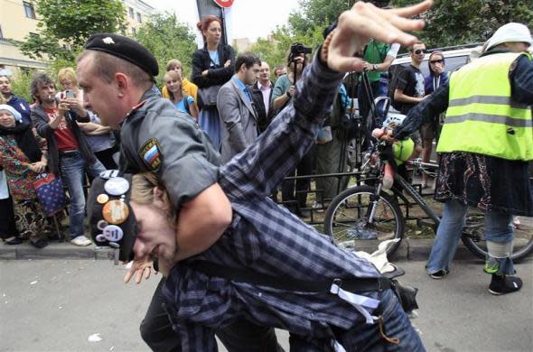 Police detain a supporter of the female punk band "Pussy Riot" members for violation of law and order outside a court building in Moscow, August 17, 2012.