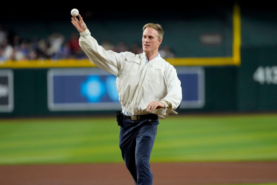 Bee keeper Matt Hilton throws out the ceremonial first pitch prior to a baseball game between the Los Angeles Dodgers and the Arizona Diamondbacks, Tuesday, April 30, 2024, in Phoenix. Hilton removed a swarm of bees on the net behind home plate that delayed the start of the game. (AP Photo/Matt York)