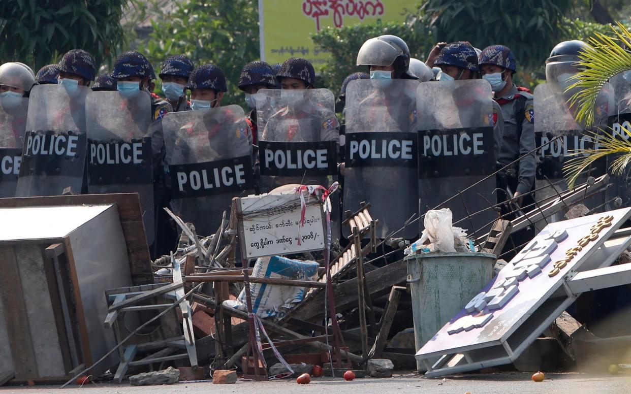 Police cross makeshift barricades set up by protesters during a protest - AP