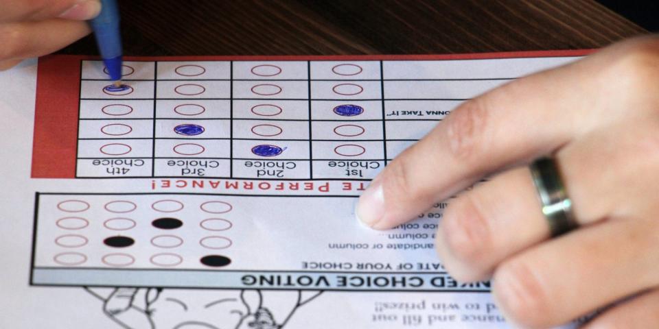 This July 28, 2022, photo shows a person completing a ballot in a mock election at Cafecito Bonito in Anchorage, Alaska, where people ranked the performances by drag performers