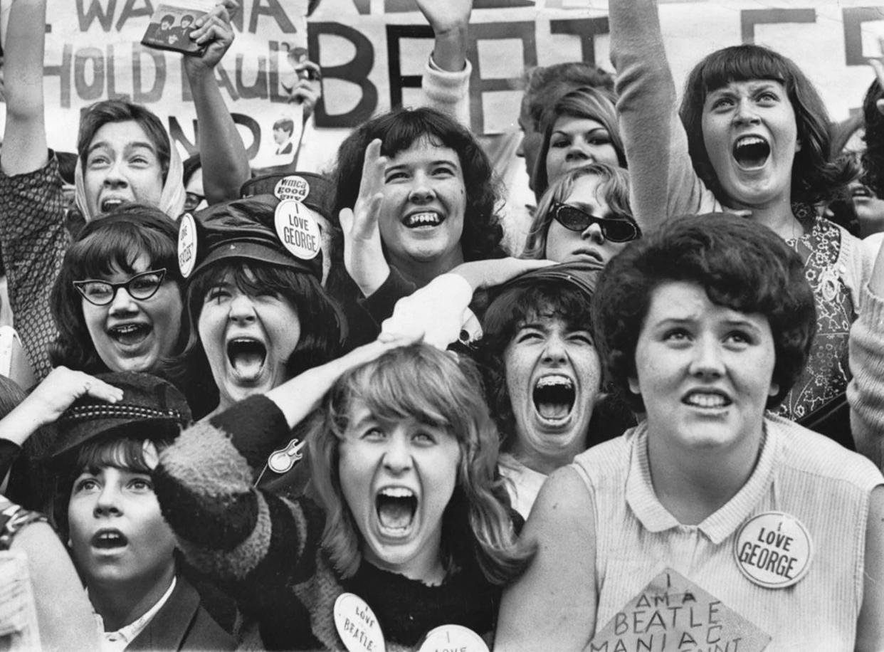 Fanáticos gritan frente a un hotel donde los Beatles se hospedaban en Nueva York en 1964. (Carl T. Gossett Jr./The New York Times).