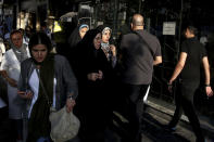 People make their way on a sidewalk in downtown Tehran, Iran, Monday, July 30, 2018. Iran's currency has dropped to a record low ahead of the imposition of renewed American sanctions, with many fearing prolonged economic suffering or possible civil unrest. (AP Photo/Ebrahim Noroozi)