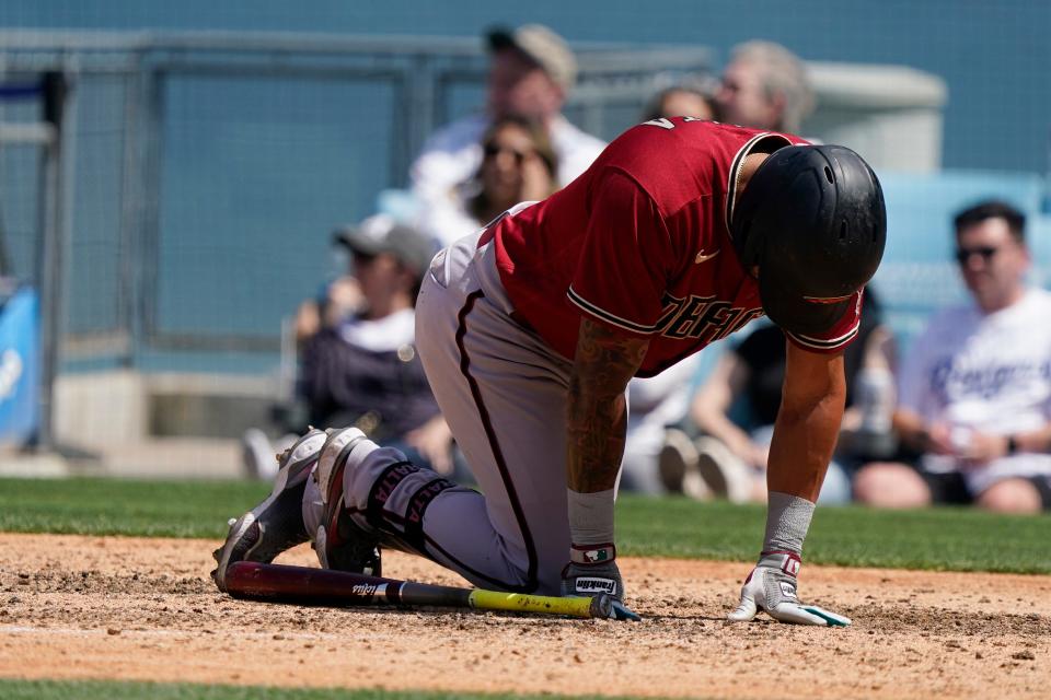 Arizona Diamondbacks' David Peralta goes down after fouling a ball off his foot during the eighth inning of a baseball game against the Los Angeles Dodgers Tuesday, May 17, 2022, in Los Angeles. (AP Photo/Marcio Jose Sanchez)