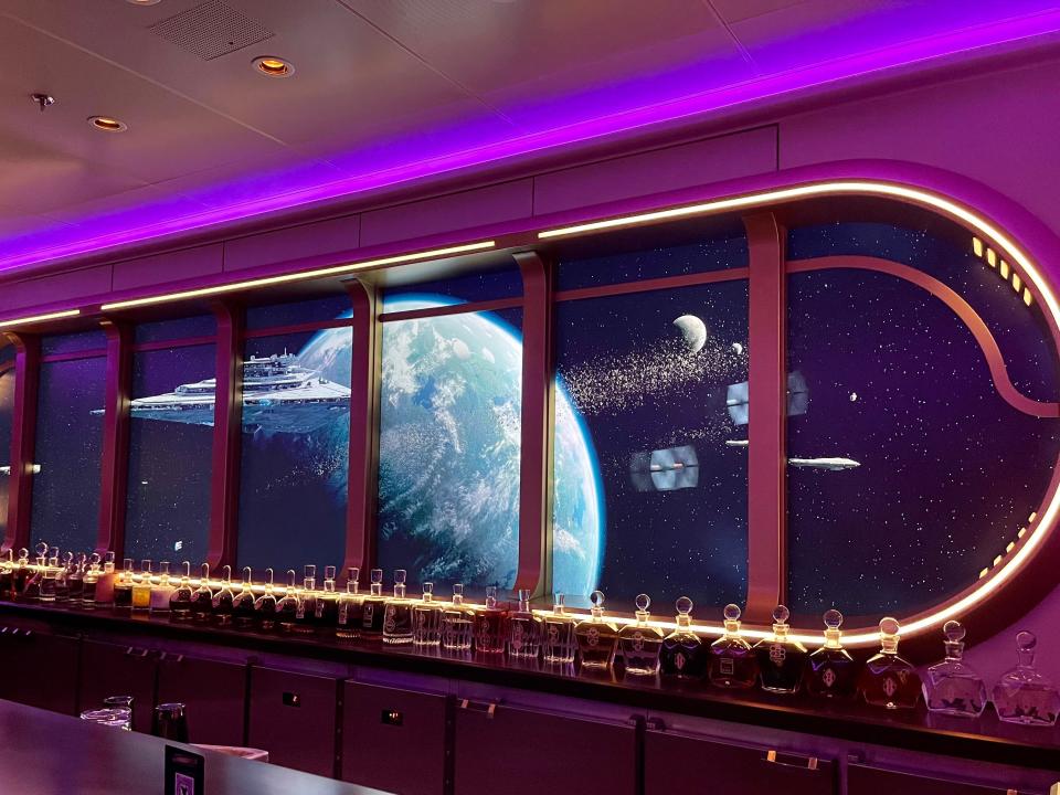 closer view of the space window behind the bar at the hyperspace lounge on disney wish