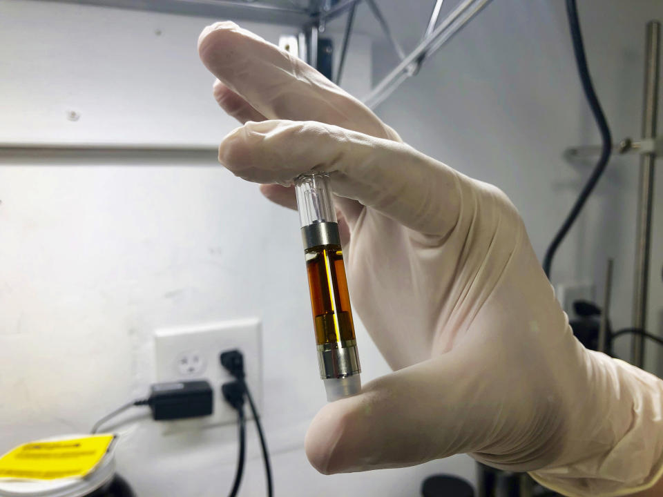 ADVANCE FOR PUBLICATION ON TUESDAY, JUNE 11, AND THEREAFTER - In this April 10, 2019, photo, Erich Berkovitz, owner of a medical marijuana processing company called PharmaEx LLC, holds a vial of a marijuana oil he extracted at his lab in Rickreall, Ore. Berkovitz runs the last medical marijuana processing company in Oregon. An Associated Press analysis has found existing medical marijuana programs take a hit when states legalize cannabis for all adults. (AP Photo/Gillian Flaccus)