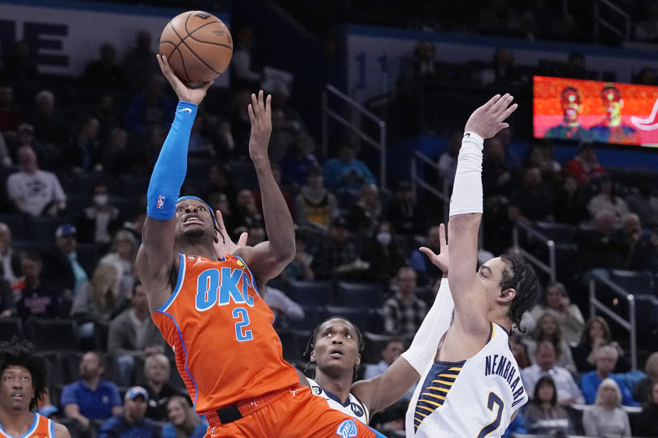 Oklahoma City Thunder guard Shai Gilgeous-Alexander (2) shoots in front of Indiana Pacers guard Bennedict Mathurin, center, and guard Andrew Nembhard (2) in the first half of an NBA basketball game Wednesday, Jan. 18, 2023, in Oklahoma City. (AP Photo/Sue Ogrocki)