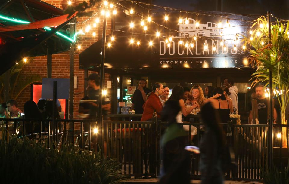 People take advantage of a warm night to enjoy the outdoor dining and bar area of Docklands on the Wilmington Riverfront.