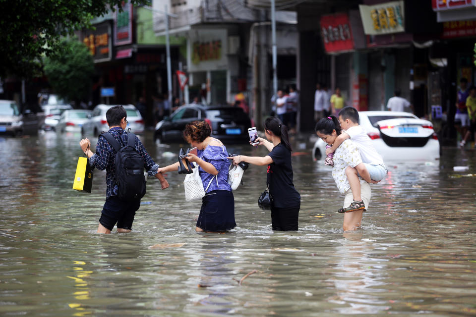 <p>People walk through a flooded street as Typhoon Hato hits Dongguan, Guangdong province, China, Aug. 23, 2017. (Photo: Stringer/Reuters) </p>