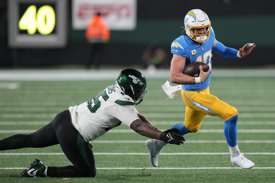 Los Angeles Chargers quarterback Justin Herbert (10) scrambles away from New York Jets defensive tackle Quinnen Williams (95) during the third quarter of an NFL football game, Monday, Nov. 6, 2023, in East Rutherford, N.J. (AP Photo/Seth Wenig)