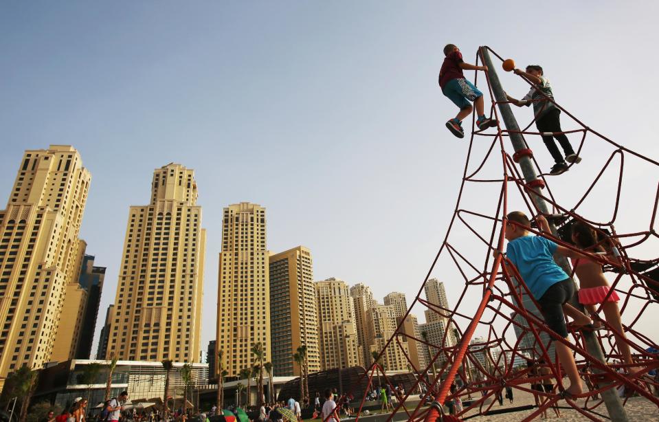 In this Saturday, April 19, 2014 photo, children play on the beach in Dubai, United Arab Emirates. Most of the luxury towers along the beach have been built only in the past decade. Some are homes to foreign professionals working in the Gulf commercial hub, others vacation properties or a place to park some cash for wealthy businesspeople from Russia, Asia and nearby Saudi Arabia. (AP Photo/Kamran Jebreili)