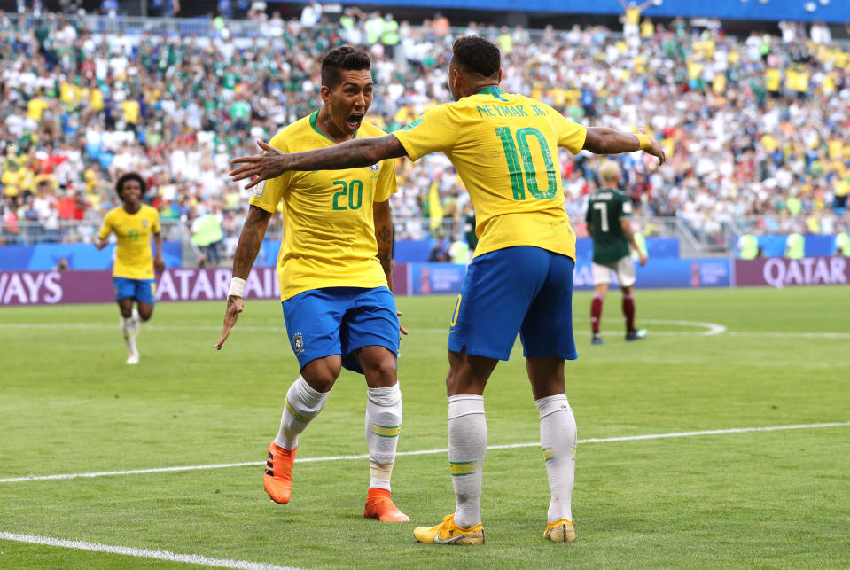 Game over: Roberto Firmino celebrates with Neymar after slotting home in the last five minutes for 2-0. (Buda Mendes/Getty Images)